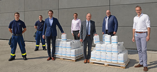 Predarea celor 100 de canistre de cinci litri de dezinfectant din producția internă a MC-Bauchemie către primarul din Bottrop, Bernd Tischler, la adresa companiei din Am Kruppwald. De la stânga la dreapta: Samuel Ata, Lukas Abermann (ambii THW Bottrop), Nicolaus Müller (director general, MC-Bauchemie), John van Diemen (șef de cercetare și dezvoltare, MC-Bauchemie), Bernd Tischler (primarul din Bottrop), Michael Schilf (Plant Manager, MC-Bauchemie) și Björn Kracht (Business Development Manager, MC-Bauchemie).